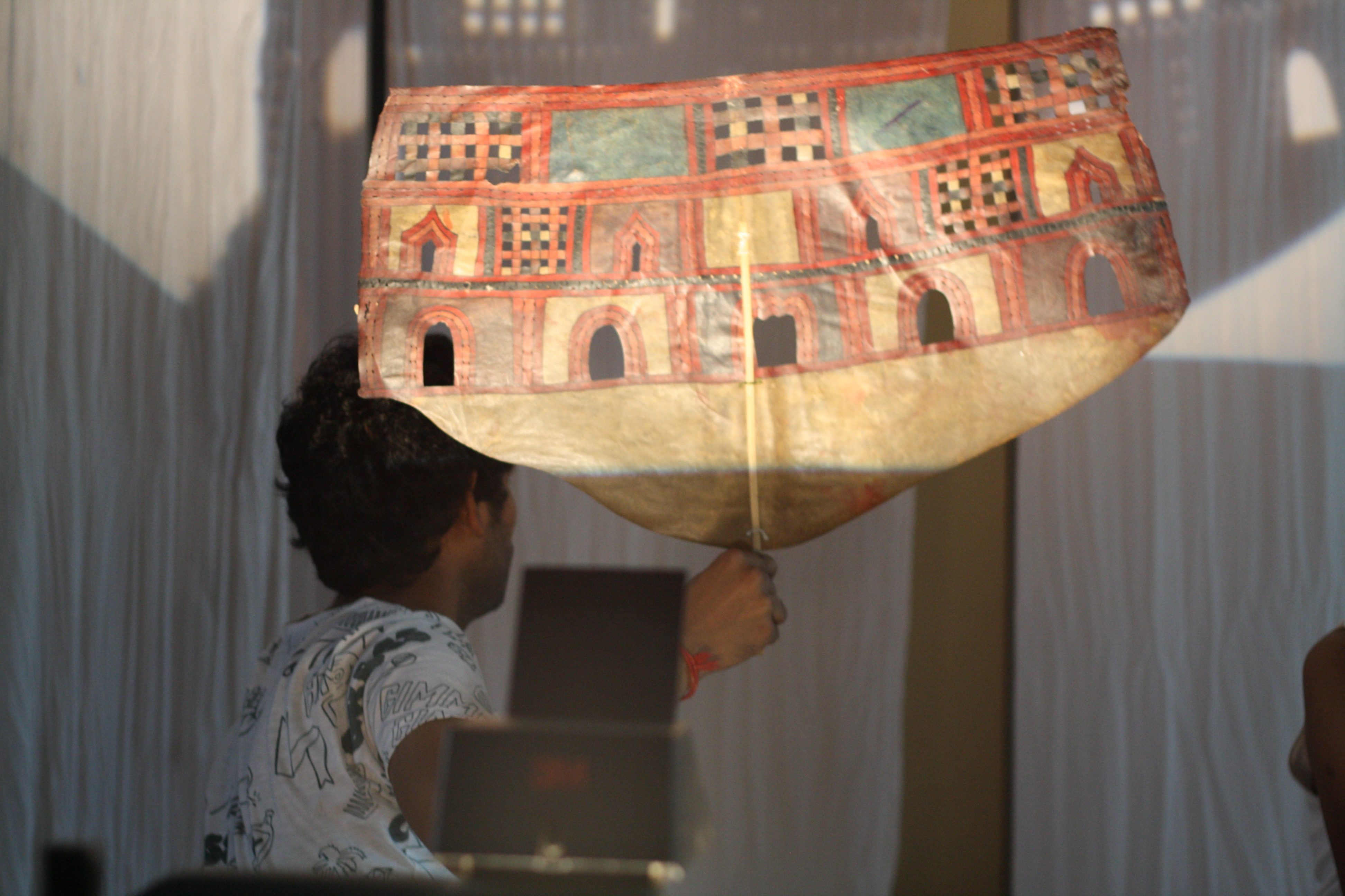 Shameem operating a leather shadow puppet in rehearsal. The puppet depicts the palace of the Pandavas: Indraprastha.